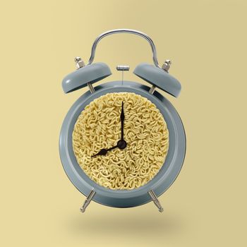 Alarm Clock with Noodle on yellow background, idea concept.