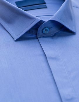 blue shirt with a focus on the collar and button, close-up