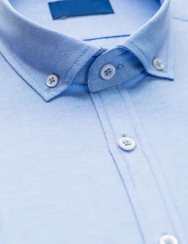 blue shirt with focus on collar and button, close-up