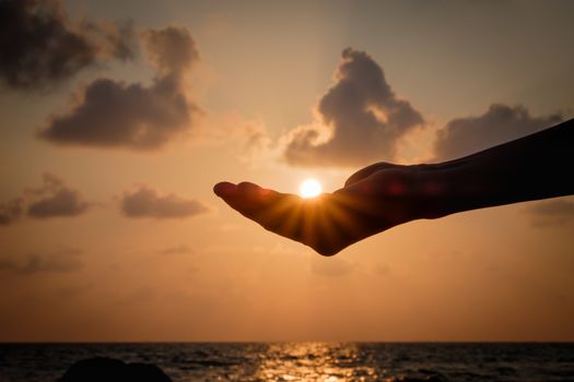 Silhouette Hands catching the falling sun during sunset.