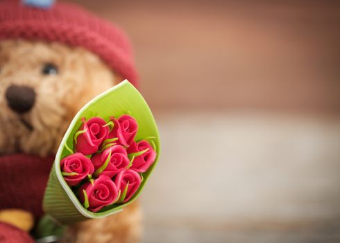 Teddy Bear holding a bouquet of roses with space for write, AF point selection and blue, Vintage tone picture.