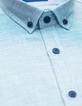 blue shirt with focus on collar and button, close-up