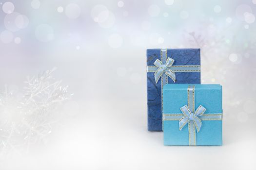 Blue gift boxes on the white fur in bokeh background, with copy space for season greeting. Merry Christmas or Happy New Year, AF point selection,blurred.