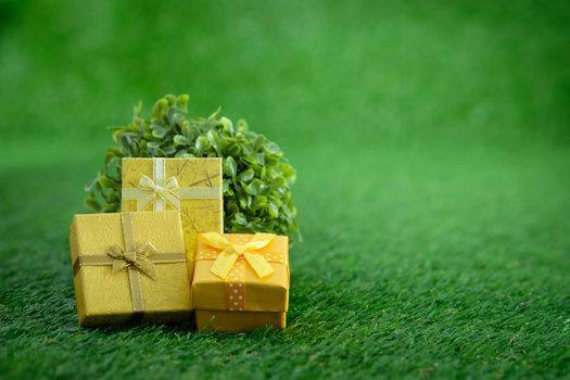 Gift box with as a present for Christmas, new year, valentine day or anniversary on green grass background, top view, space for write.