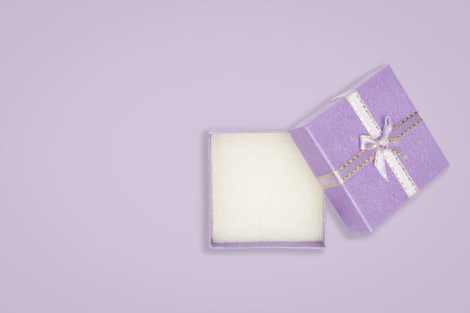 Top view of opened purple gift box on purple background. with copy space for text.