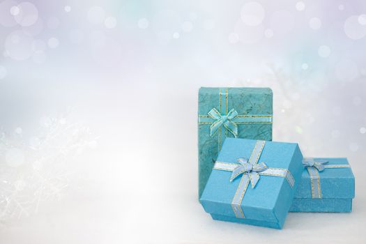 Blue gift boxes on the white fur in bokeh background, with copy space for season greeting. Merry Christmas or Happy New Year, AF point selection,blurred.