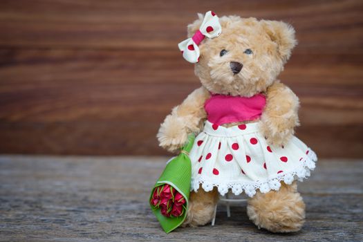 Teddy Bear holding a bouquet of roses with space for write, AF point selection and blur, Vintage tone picture.
