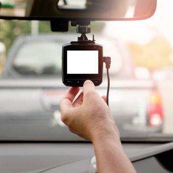 Hand-tuning car camera for safety on the road accident with white screen.