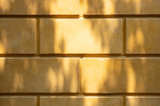 Yellow brick wall in the Roman era for background with shadow.