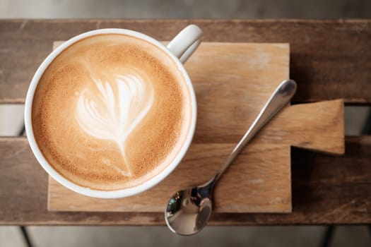 Hot coffee in a glass of white ceramic put on wooden board with copy space to write. Classic chrome stlye.