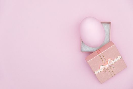 Egg shell on pink background. Minimal and easter concept, with copy space to write.