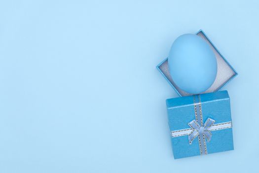 Egg shell on blue background. Minimal and easter concept, with copy space to write.