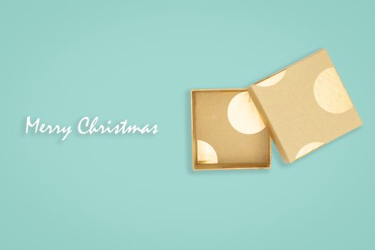 Top view of opened golden gift box on green background. with copy space for text.