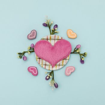 Heart-shaped pillow and mini dish, folk on blue background, valentine concept.