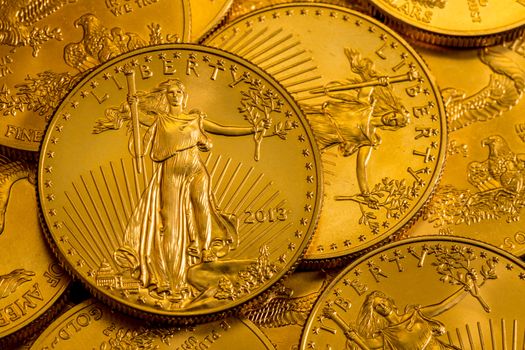 Pile of golden coins with Liberty on US Treasury issue Gold Eagle one ounce pure gold coin