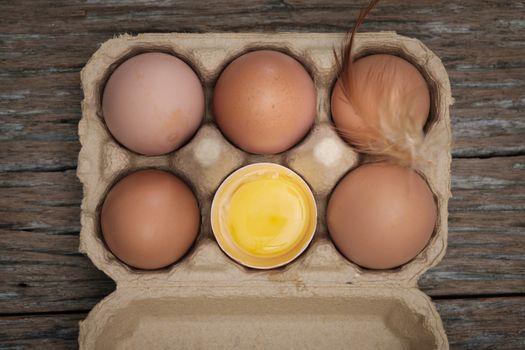 Top view-Yolk and eggs in carton box arranged on a wooden scene, Egg is beneficial to the body, Food concept.