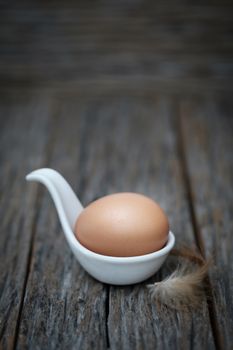 Still life-An egg on white ceramic spoon arranged in a rustic scene, Eggs is beneficial to the body, Food concept.