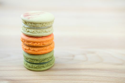 Sweet and colorful macaroon cookies tower on wooden background with blank space,selective focus, Dessert.