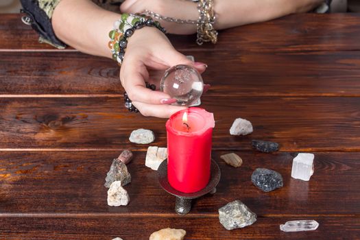 Fortune teller predicts fate using a magic ball, stones and a lit candle.A Gypsy telling fortunes by the hand.Christmas fortune telling and fortune telling.Spiritism and magic sessions.Psychicat work