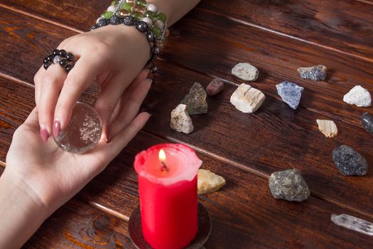 Fortune teller predicts fate using a magic ball, stones and a lit candle.A Gypsy telling fortunes by the hand.Christmas fortune telling and fortune telling.Spiritism and magic sessions.Psychicat work