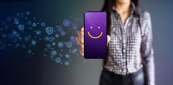 Customer Experiences Concept. Happy Female Client Giving Smiling Emoticon Rating, Positive Review via Smartphone. Client's Satisfaction Surveys on Mobile Phone. Front View