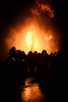 firefighters with fire hose fight with fire at night