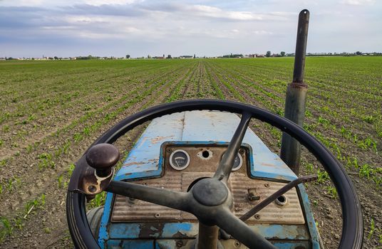 Dashboard of an Old rusty tractor in fields during spring time