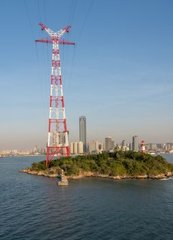 Tall electricity power tower on small island in harbor of Xiamen in China