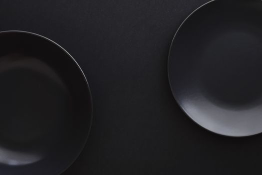 Empty plates on black background, premium dishware for holiday dinner, minimalistic design and diet concept