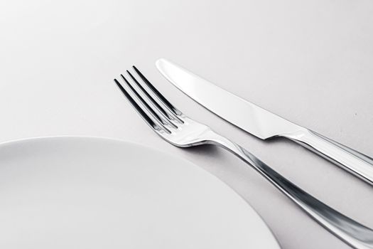 Empty plate and cutlery as mockup set on white background, top tableware for chef table decor and menu branding design