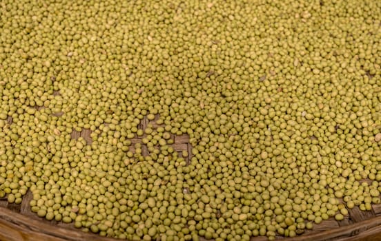 Large basket of green split peas drying inside Tulou in Fujian Province in China