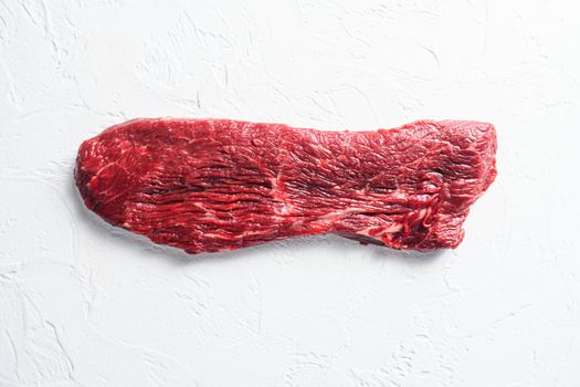 Raw tri tip, bottom sirloin steak on a white stone background top view.