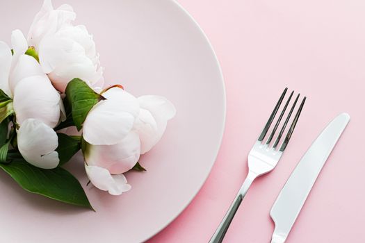 Dining plate and cutlery with peony flowers as wedding decor set on pink background, top tableware for event decoration and menu branding design