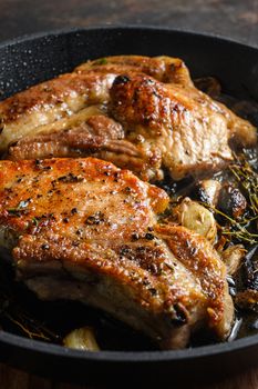 Barbecue Pork Chops on the bone with seasonings and grilled on hot skillet with smoke just from the fire close up side view vertical