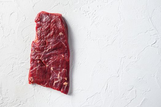 Raw skirt or flank steak,on a white stone background top view space for text