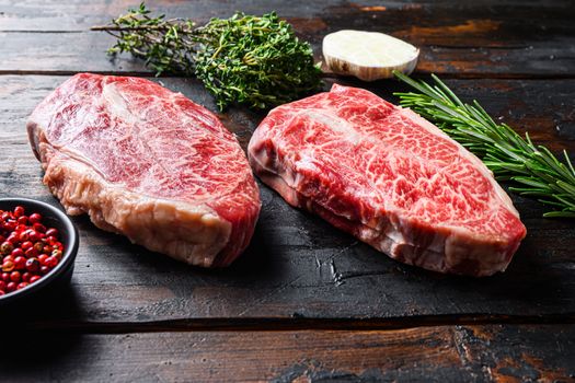 Top blade cut Steak or Feather steak raw meat over old wood table background. Side view.