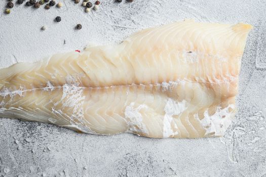 Cod fillets on a grey concrete background for the preparation of a healthy dish top view close up.