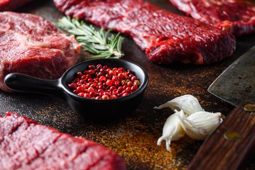 Side view Close up on red pepper near machete Steak, Flank steak, cut near denver alternative beef steak and a cleaver butcher meat knife a rustic metall background.