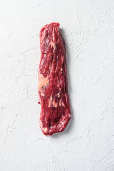 Raw skirt, machete steak on a white stone background vertical.