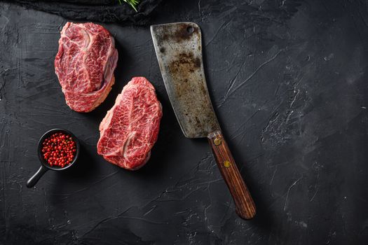 Raw top blade cut organic meat ner butcher meat clever knife for bbq or gtrill top view over black stone background .