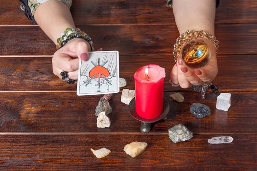 Bangkok, Thailand, March.15.20.A fortune teller holds a magic ball and a Tarot card with a heart.The Gypsy lays out Tarot cards and guesses for the future.Magical sessions with the cards.Clairvoyance