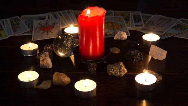 Bangkok,Thailand,March.15.20.On the table are fortune-telling cards,a magic ball, magic crystals and a lighted candle.Magic sessions with clairvoyance cards.Reading maps by candlelight