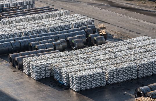 Ingots of aluminum and rolls of steel line the quayside in the Port of Koper in Slovenia
