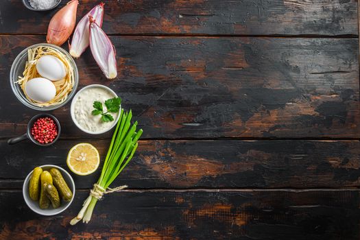 Organic lemon ranch dressing Tartar sauce. With ingredients capers, cucumbers, parsley, lemon and eggs. Top view over dark wood rustic old surface space for text.