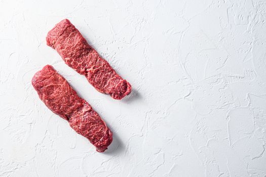 Raw set of denver, machete steak on a white stone background space for text