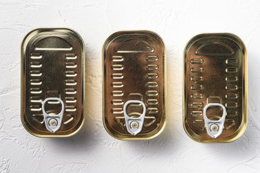 Set of same size closed canned food, fish , fruits, vegetables, meat, soup different types of shapes top view onwhite textured background top view.