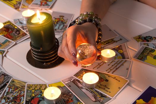 Bangkok,Thailand,March.15.20.Fortune teller predicts fate using a magic ball,stones and a lit candle.A Gypsy telling fortunes by the hand.Christmas fortune telling and fortune telling.Psychic at work