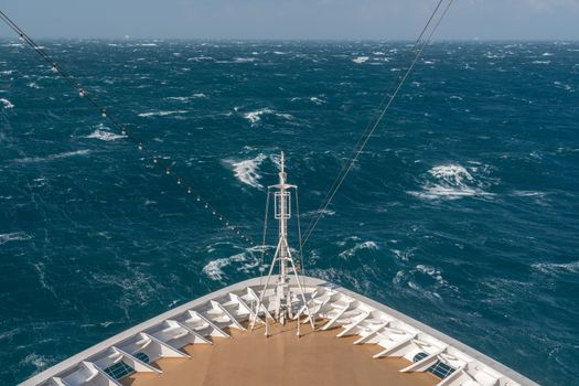 View from front at the rough seas and waves forward of bow of cruise ship