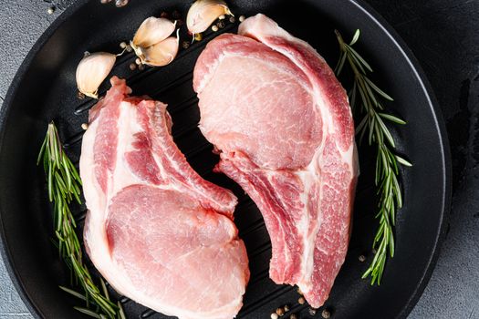 pork ribeye roast in frying pan grill skillet with herbs, spices close up grey background . Close up