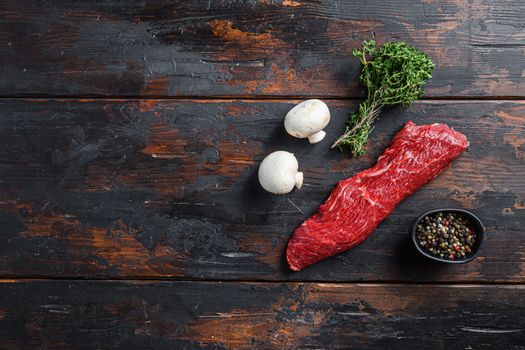 Tri tip steak with fresh seasoningsm thyme, for BBQ on wooden background, top view space for text.